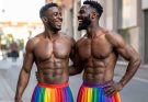 Two muscled Black gay men wearing rainbow-colored skirts to demonstrate the power of absurdity in breaking stigma and role associated pressures and anxiety.