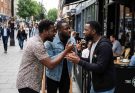 a group of Black gay men arguing following a disagreement over sex roles and toxic masculinity and gossiping